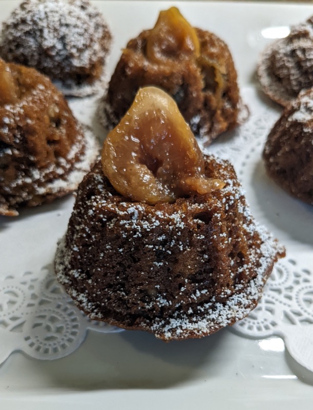 Spice cake topped with poached fig and powdered sugar on a doily