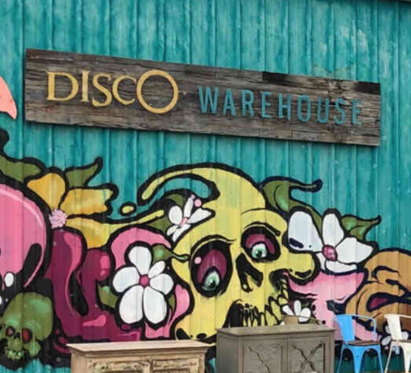Image of the Disco Warehouse sign on the side of a blue warehouse